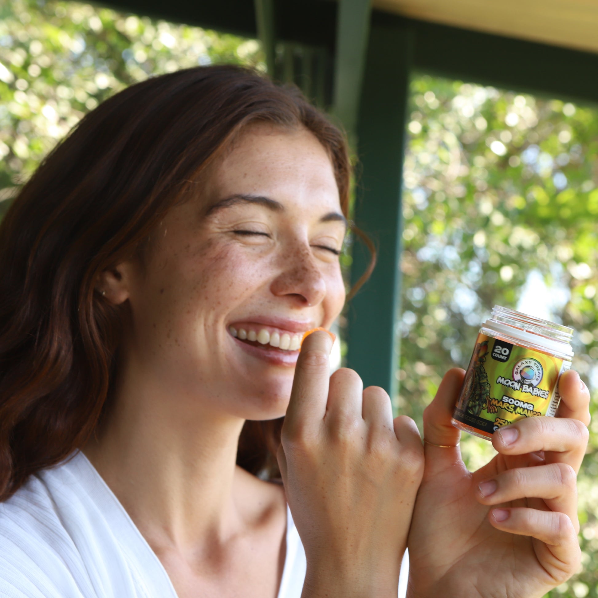 Mars Mango Delta 8 Gummies - 25MG Delta 8 Mango Flavored Edibles - Woman Smiling Eating Gummy - Galaxy Treats in the U.S.