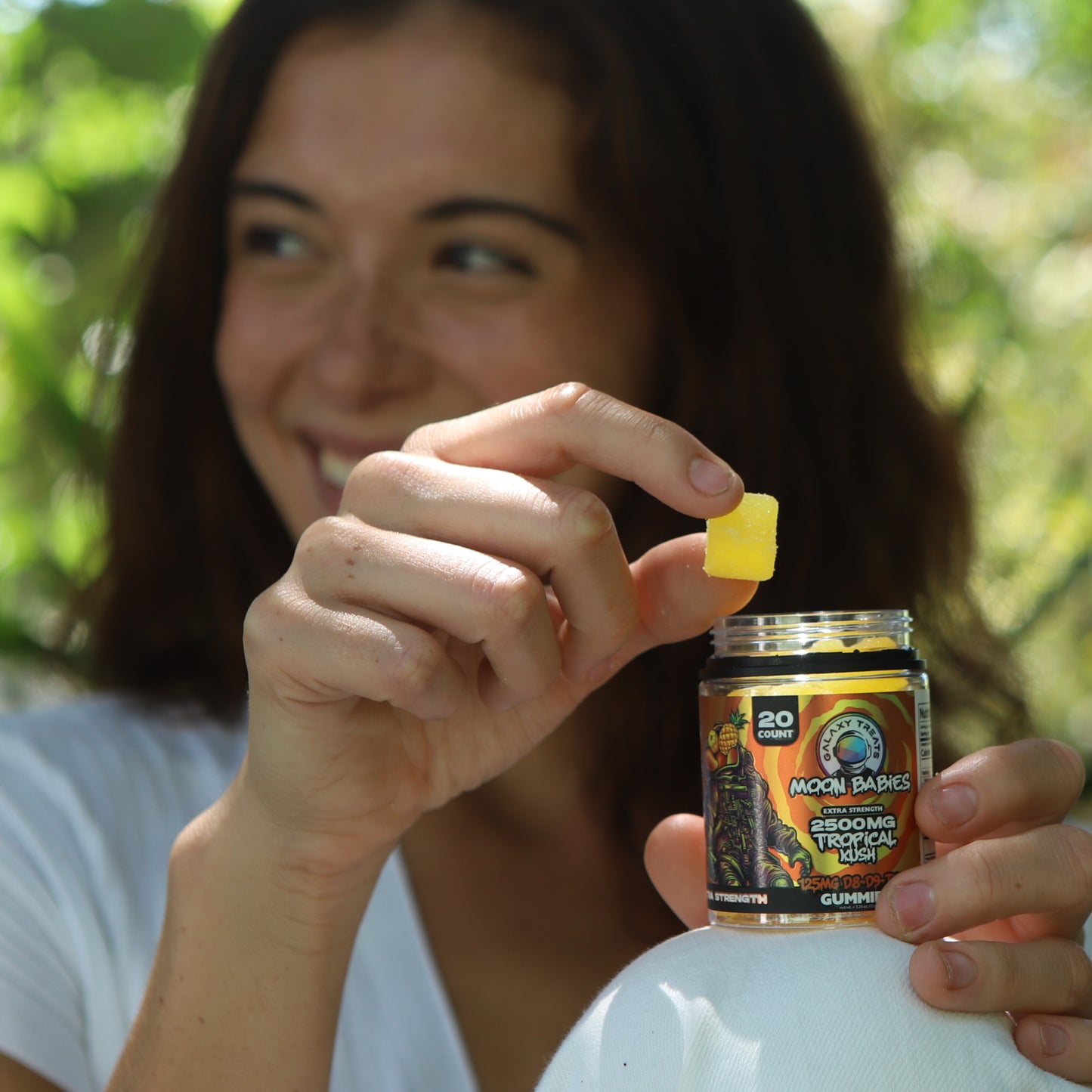 Tropical Kush Extra Strength Delta Edibles - 125MG Tropical Flavor - Woman Holding Gummy Jar - Galaxy Treats in the U.S.