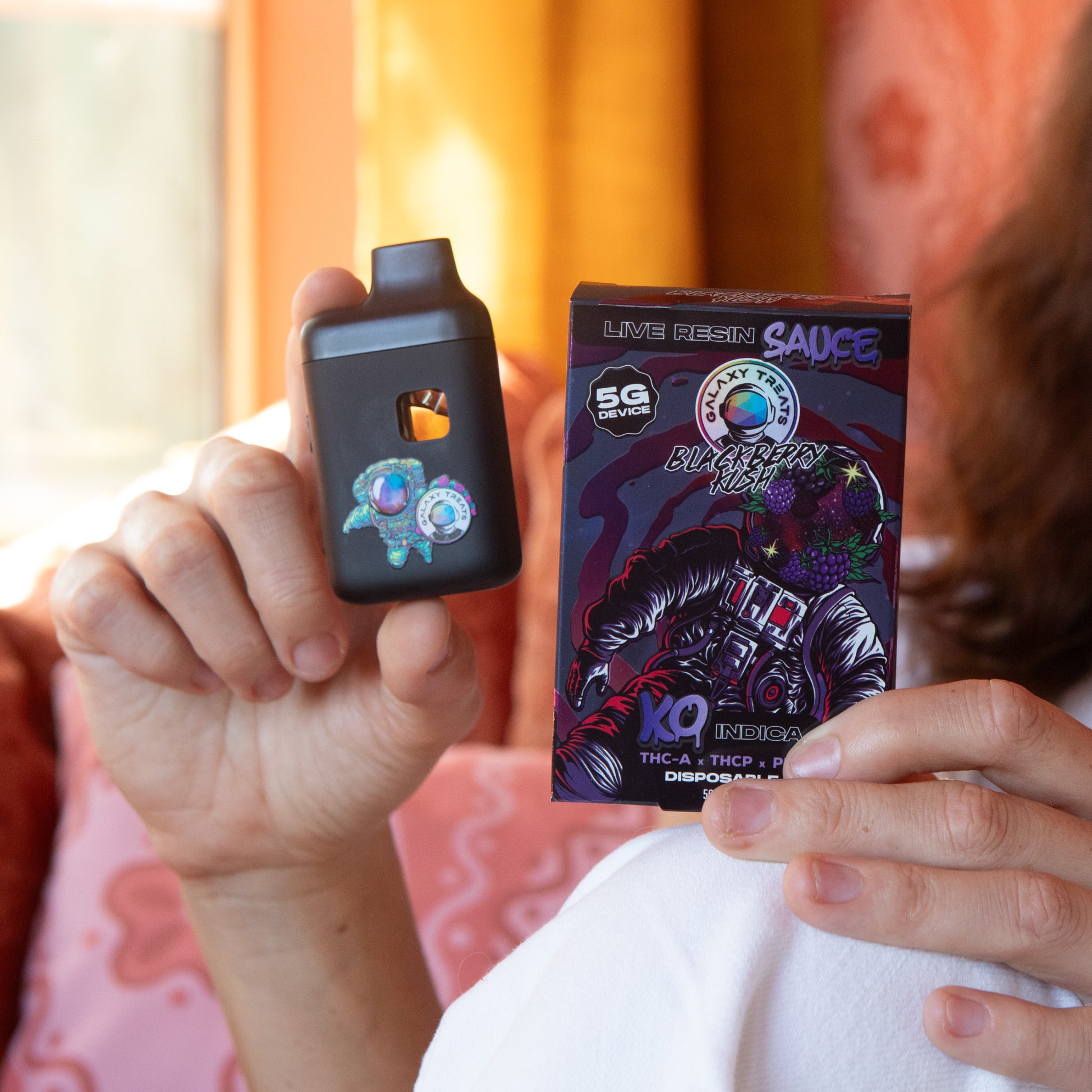 Blackberry Kush Vape Pen - Live Resin Indica - Woman Holding Vape Device and Packaging - Galaxy Treats in the U.S.