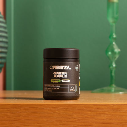 Green Apple Delta 9 Gummies - 10MG Delta 9 - Jar Sitting on Table - Galaxy Treats in the U.S.