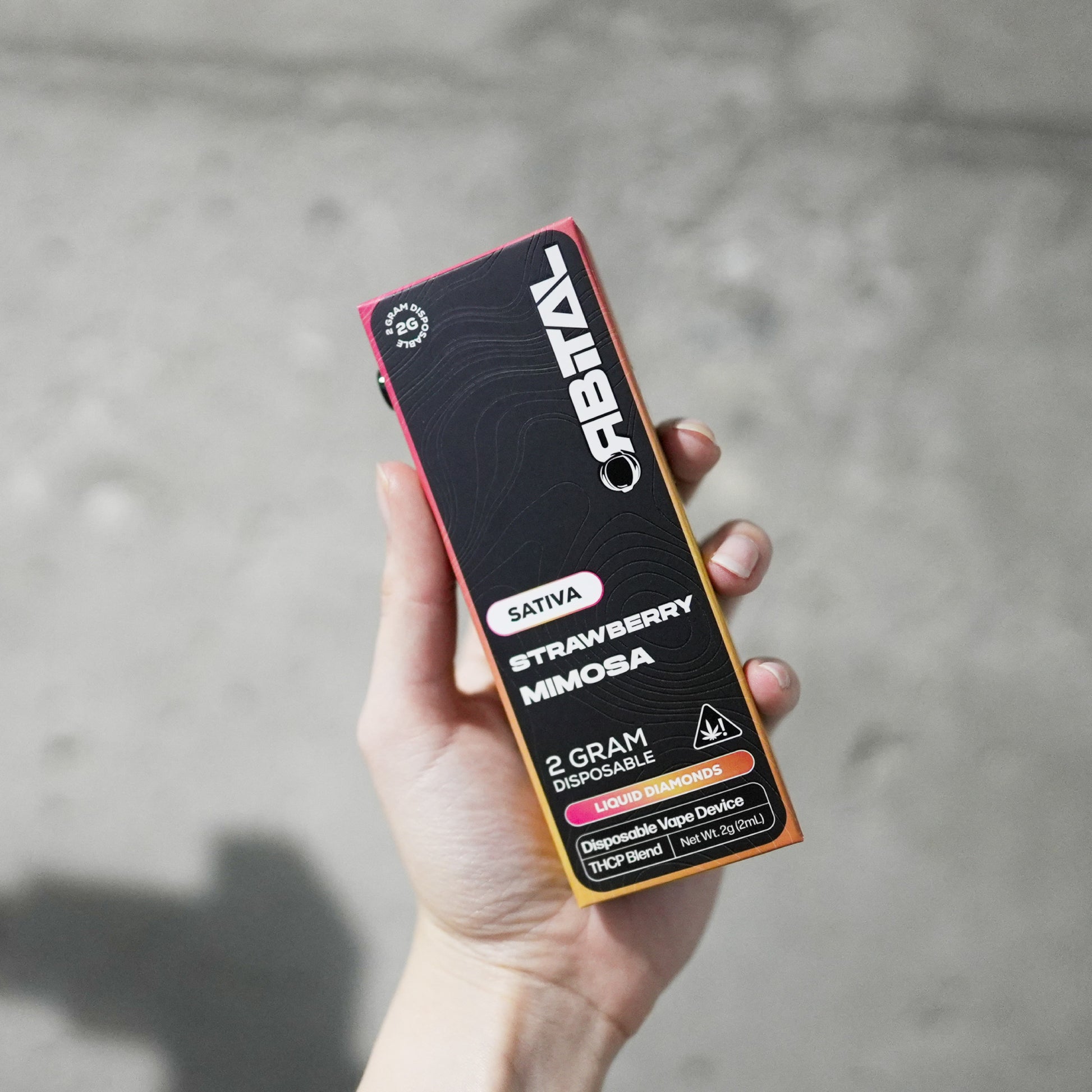 Strawberry Mimosa Vape - Orbital 2G Sativa Disposable - THCP Liquid Diamonds - Front Shot of Hand Holding Packaging Box - Galaxy Treats in the U.S.